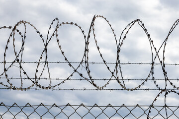 A barbed wire fence with the sky behind