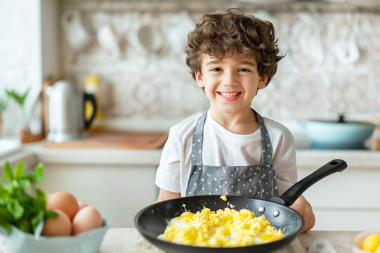 Boy in the kitchen apron with a self-prepared dish