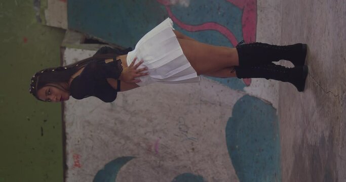 Within the indoor skatepark, a young girl in a mini skirt explores the scene.