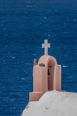 Santorini, Greece, May 5, 2024. Oia. Bell of a church with its white cross facing the sea