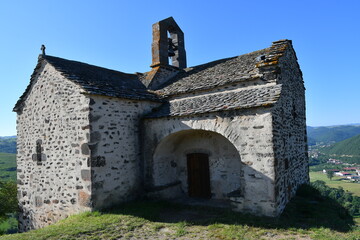 La chapelle Sainte Madeleine avec son clocher et sa porte d'entrée dominant au fond de la vallée...