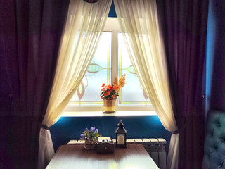 Curtains frame a sunlit window with vibrant red flowers on sill. Bright Morning Sunlight Through...
