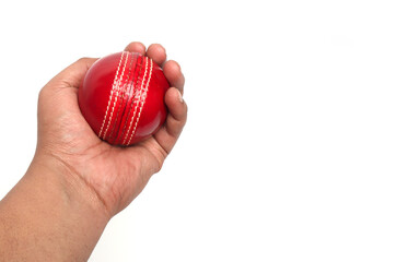 red cricket leather ball in player's hand on the white background