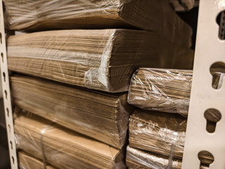 Close-up view of neatly arranged paper bags on shelves in a restaurant storage room, prepared for...
