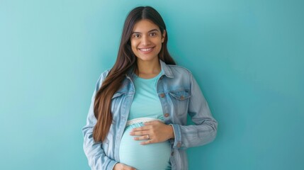 Smiling pregnant hispanic woman holding an alarm clock against a blue background