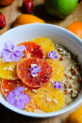 Oatmeal or oat porridge with banana citrus fruits fresh orange and blood oranges and almond 