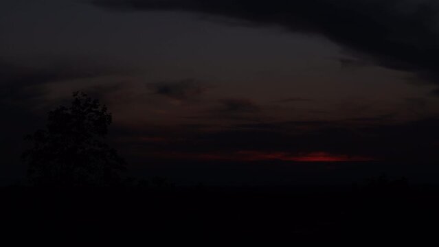 breve timelapse con inquadratura dettagliata che mostra l'evoluzione del cielo nuvoloso al tramonto, visto da un ambiente naturale