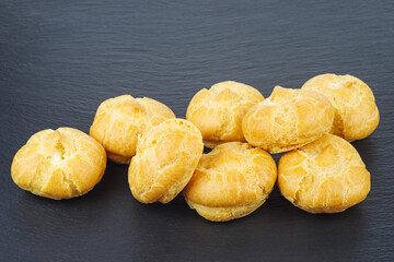 Choux cream puff pastry isolated in black background, sweet food, bakery