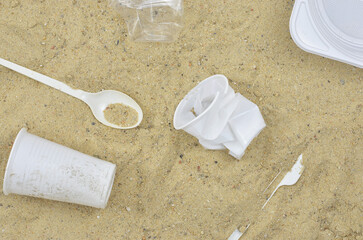 Garbage on the beach, white plastics (waste) on sand, top view. After party, after summer festival, after picnic on a beach. 