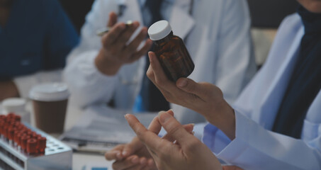 Team of medical staff having morning meeting in boardroom. Doctors and nurses looking at digital tablet.