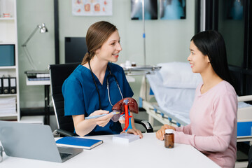 Woman Doctor and patient discussing something while sitting at the table .