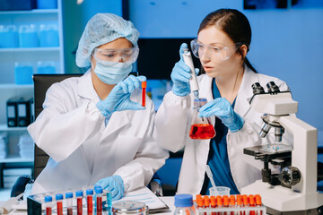 Young scientists conducting research investigations in a medical laboratory, a researcher in the...