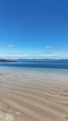 Picturesque beach landscape with a sandy coastline and clear water in Tasmania, Australia.