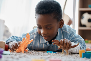 Boy, home and happy on playing with toy on floor for fun, relax and break for child development....