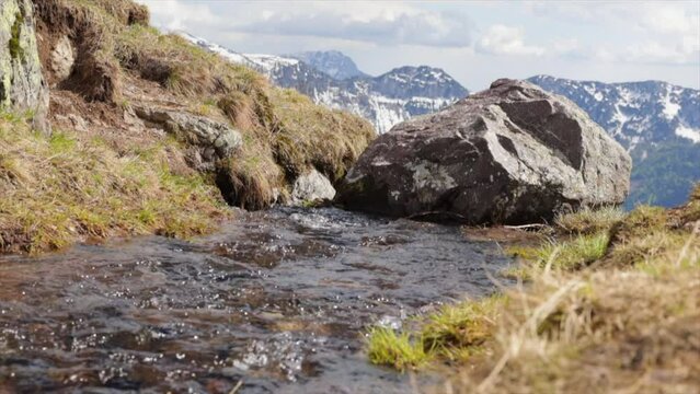 ripresa in tempo reale con visuale in primo piano che mostra l'acqua limpida che scorre lungo un ruscello di montagna