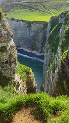 Cliffs, landscape along the Falaise d'Aval, view of the La Manche. Etretat, Normandy, France, English Channel. Natural rocks, coast. Rocks of the village of Etretat in spring in cloudy weather