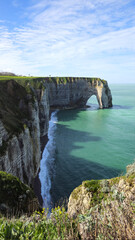 Obraz premium Cliffs, landscape along the Falaise d'Aval, view of the La Manche. Etretat, Normandy, France, English Channel. Natural rocks, coast. Rocks of the village of Etretat in spring in cloudy weather
