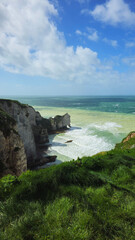 Cliffs, landscape along the Falaise d'Aval, view of the La Manche. Etretat, Normandy, France, English Channel. Natural rocks, coast. Rocks of the village of Etretat in spring in cloudy weather