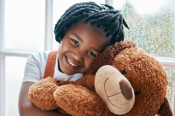 Black girl, portrait and teddy bear in house by window for happy, wellness and playing with toys. Homeless child, smile and stuffed animal in orphanage or children home for love, friendship and hug