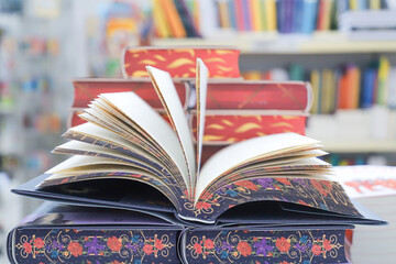 Open book on table with blur bookshelf background