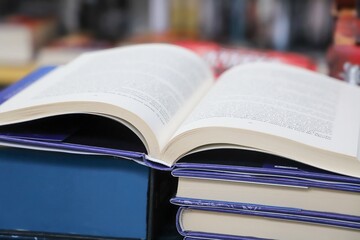 Open book on table with blur bookshelf background