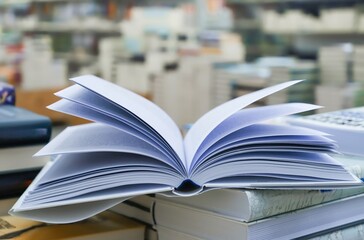 Open book on table with blur bookshelf background