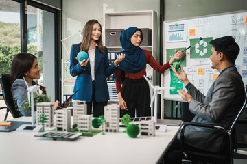Diverse team, middle-aged Asian businessman, Caucasian young businesswoman, Muslim hijab-wearing...