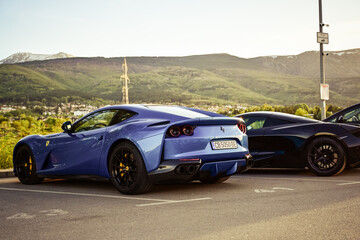 Fototapeta premium Italy- May 2024 Ferrari Blue car parked near a mountain. luxury sport Italian car