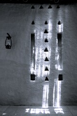 Low angle view on old iron lamp on clay Arabic wall