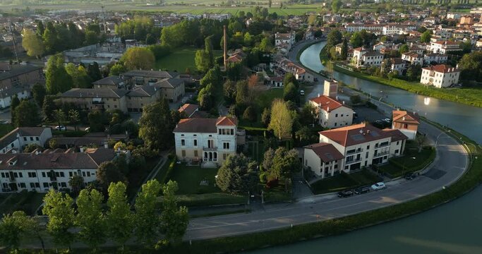 Mira Town And Brenta Canal In Sunrise With Bright Sun In Veneto, Italy. - aerial shot