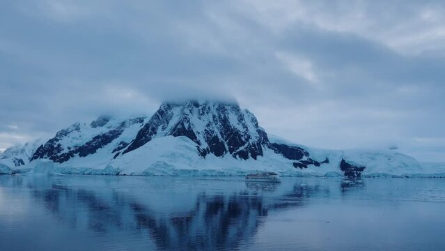 Greg Mortimer cruise ship floating past the Lemaire channel in Antarctica.