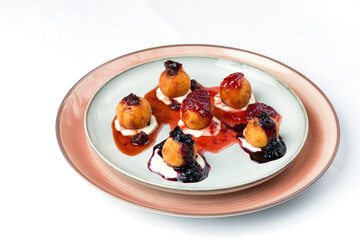 Papanasi traditional Romanian dessert served with sour cream and fruit jam.