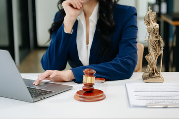 Female lawyer in the office with brass scale on wooden table. justice and law concept