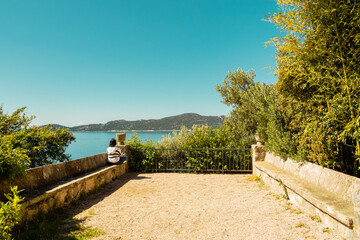 Jeune femme assise, tournée vers la mer, terrasse de l'arboretum de Trsteno, Croatie