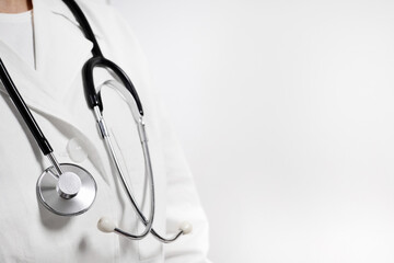 Doctor in a white medical coat with a phonendoscope around his neck with copy space