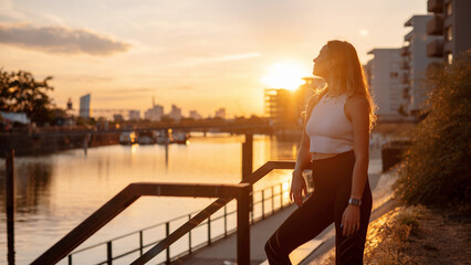 Caucasian woman in sport clothes for fitness relaxing after exercises on the street during the...