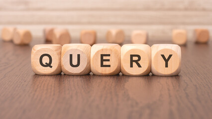 the text 'QUERY' is written on wooden cubes on a brown background