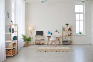 Modern children's room at home. Spacious interior with a desk for studying, a chair, bookshelves, chalkboard, Earth globe, green plants, boxes, toys, and a play area with a rug, and laminate flooring