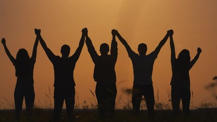 Success team hands up. business a team teamwork concept. group of people holding hands raised their hands up silhouette in nature sunset. motivational video for team business lifestyle video