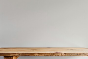 A medium shot of a wooden table standing against a white wall, highlighting its simple design and natural material - Powered by Adobe