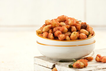 Spicy Flavored Peanut or Kacang Thailand in a Bowl on White Table Background.
