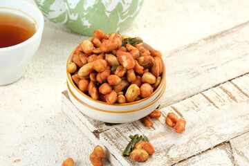 Spicy Flavored Peanut or Kacang Thailand in a Bowl on White Table Background.