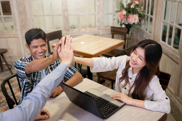 Portrait of multiethnic business colleagues high five during a meeting