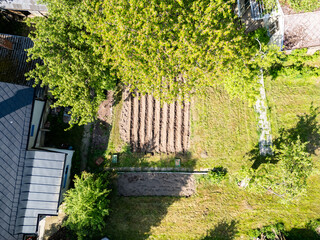 Aerial drone top down view of potato field prepared for growing in small old fashioned garden.