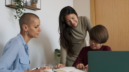 Lesbian couple helping their non-binary child to do homework at home - Powered by Adobe
