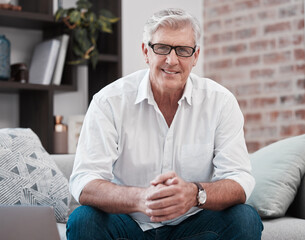 Portrait, mature and businessman with glasses on couch for working from home, laptop and company...