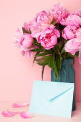 Envelope with pink peony flowers on pink background.