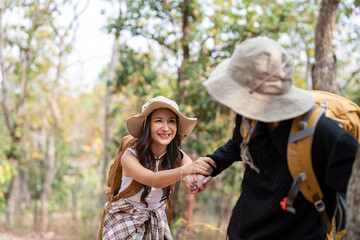 Happy LGBT lesbian couple travel enjoy hiking with backpack in forest trail