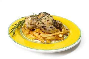 Garlic chicken thighs with French fries, served on a yellow plate, with a sprig of rosemary. Isolated on a white background. Spanish food concept.