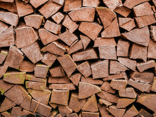 Stack of chopped firewood. Cheap budget heating material. Light brown wood color. Home comfort concept. Winter cold season preparation concept.